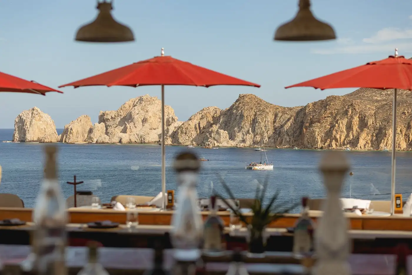El Arco de Cabo San Lucas visto desde un beach club con sombrillas rojas