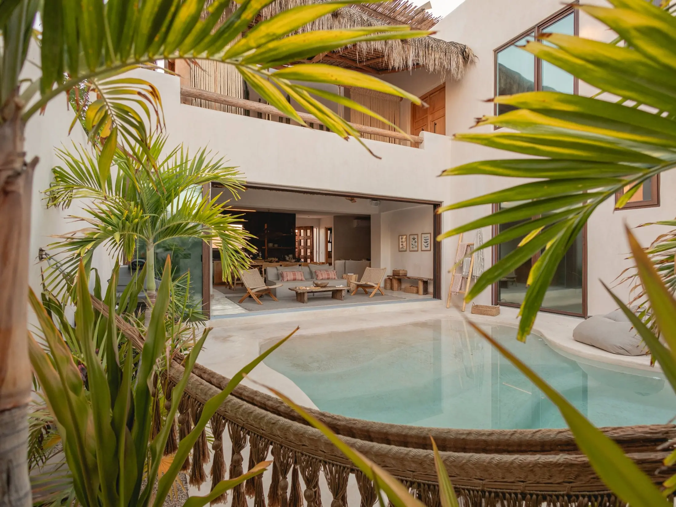 Villa con piscina privada entre palmeras, a la luz de la tarde